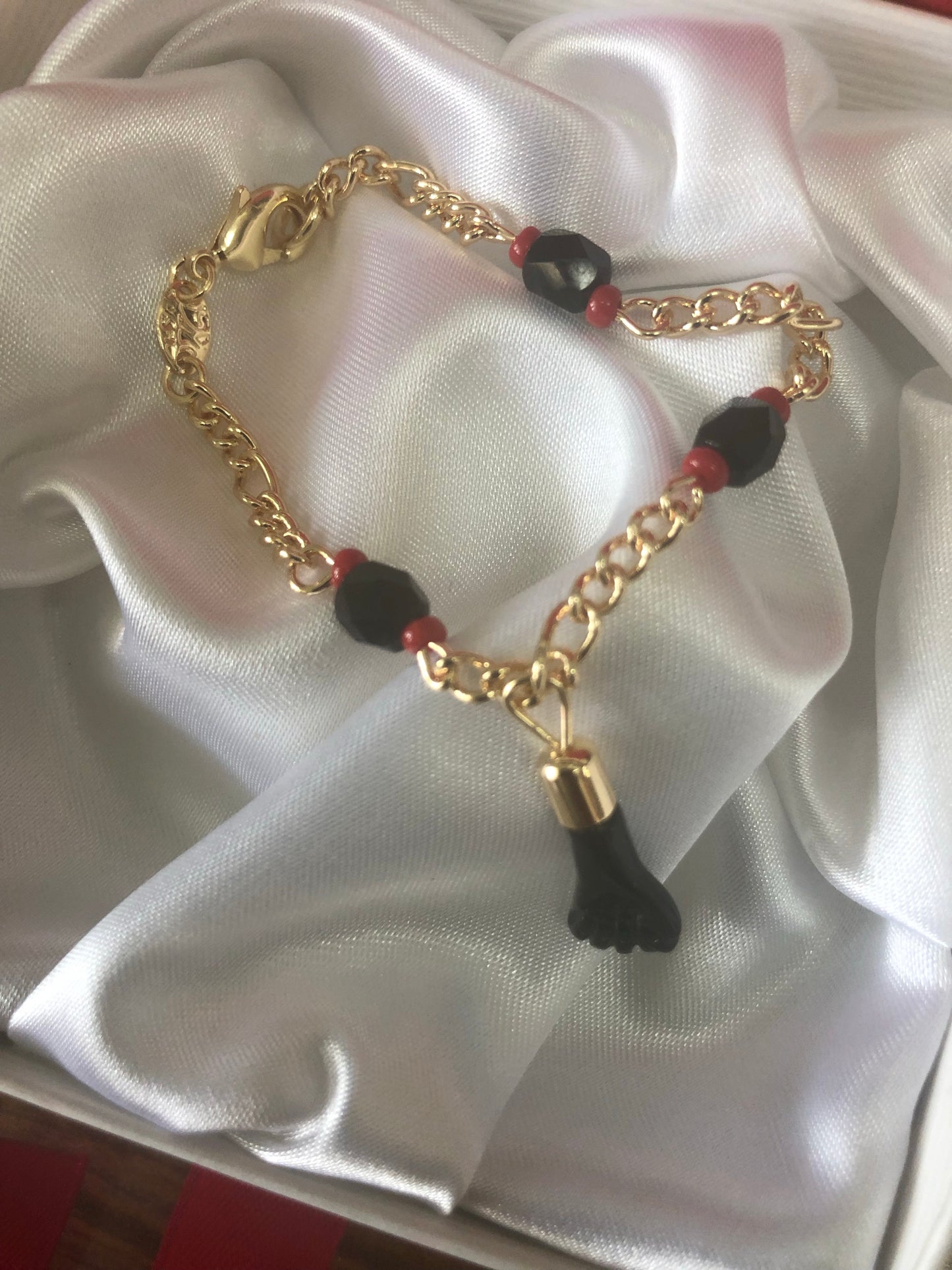 Gold plated black hand baby bracelet.